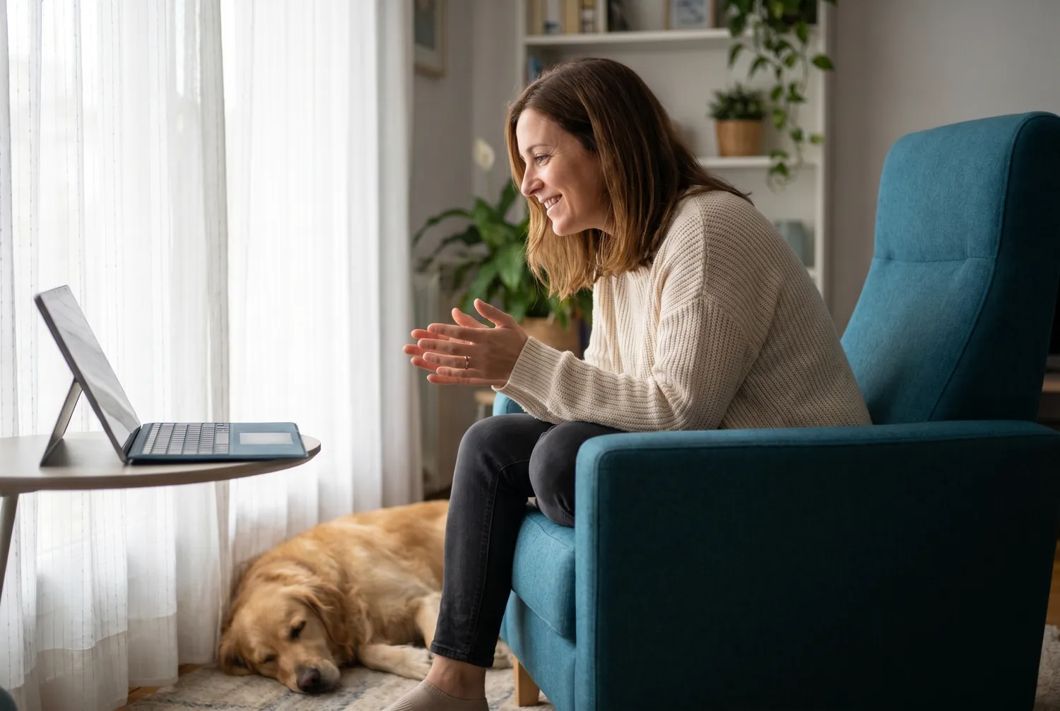 Woman at home in a teal armchair during an online psychiatry video visit Woman at home in a teal armchair during an online psychiatry video visit
