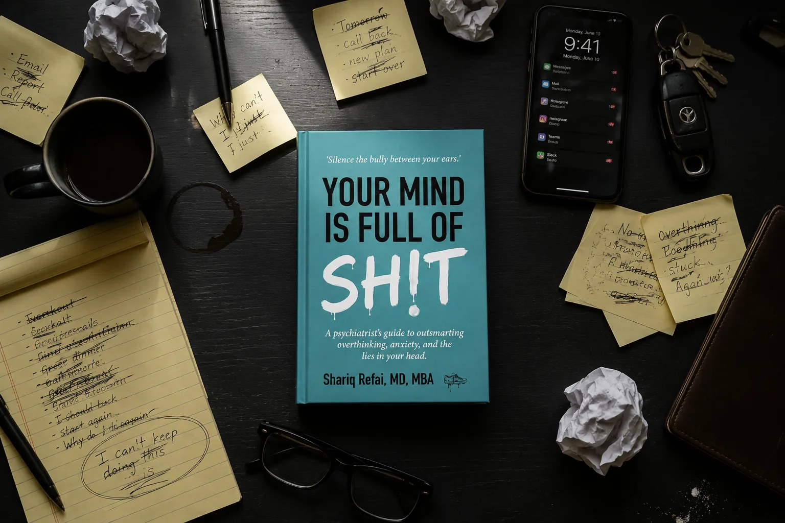 Shariq Refai's book Your Mind Is Full of Sh!t on a busy desk with coffee, sticky notes, and glasses Shariq Refai's book Your Mind Is Full of Sh!t on a busy desk with coffee, sticky notes, and glasses