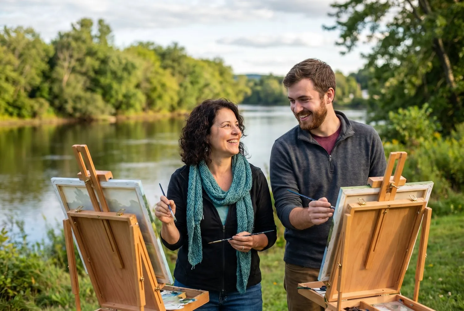 Two artists painting beside the Kennebec River in Augusta, Maine
