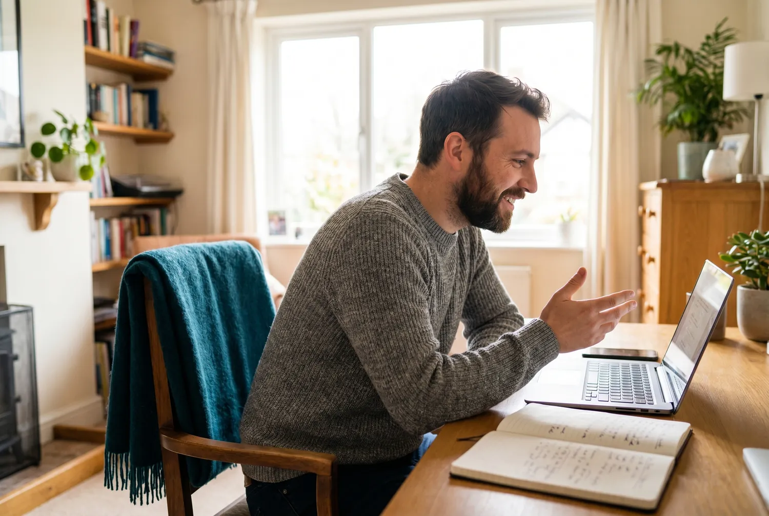 A man at a home desk in an attentive video conversation on a laptop A man at a home desk in an attentive video conversation on a laptop